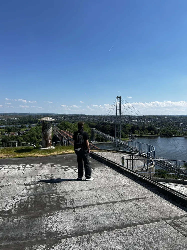 Silhouette sur un toit plat face au pont et à la Meuse