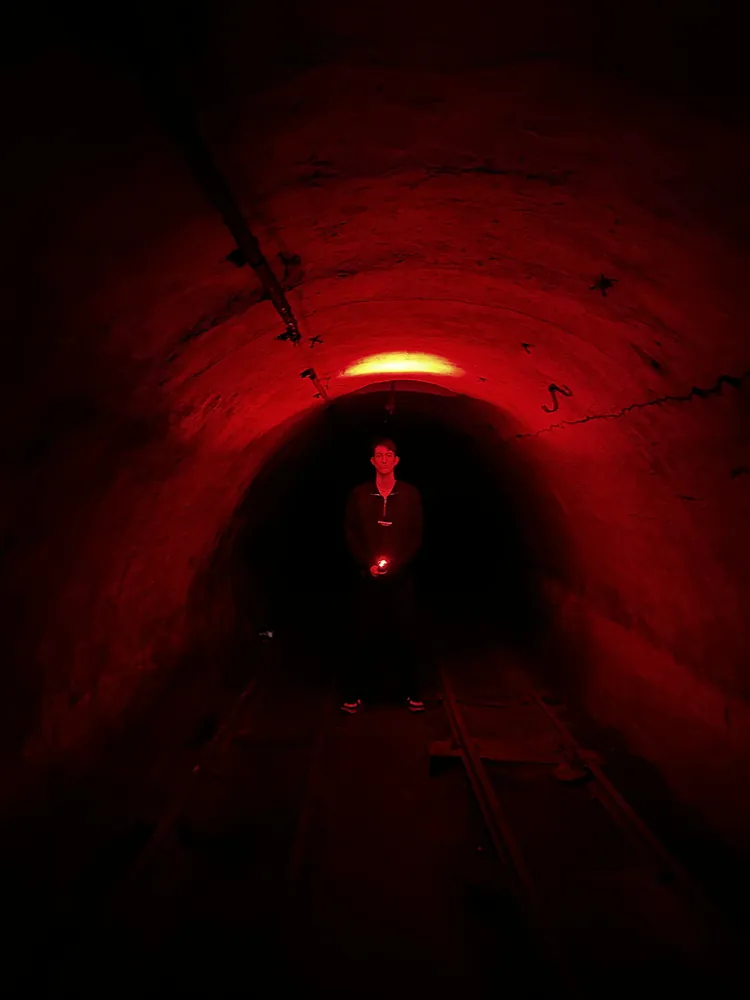 Tunnel éclairé en rouge avec une silhouette au fond