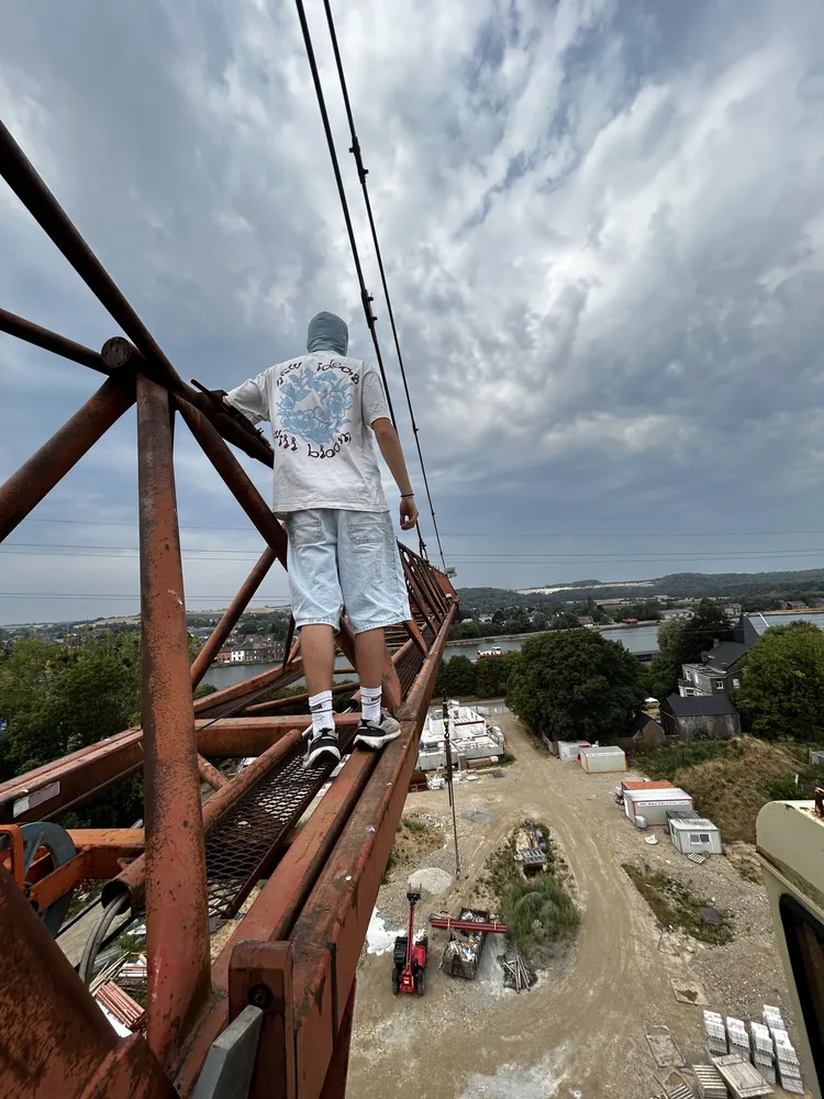 Personne debout sur la flèche d'une grue de chantier